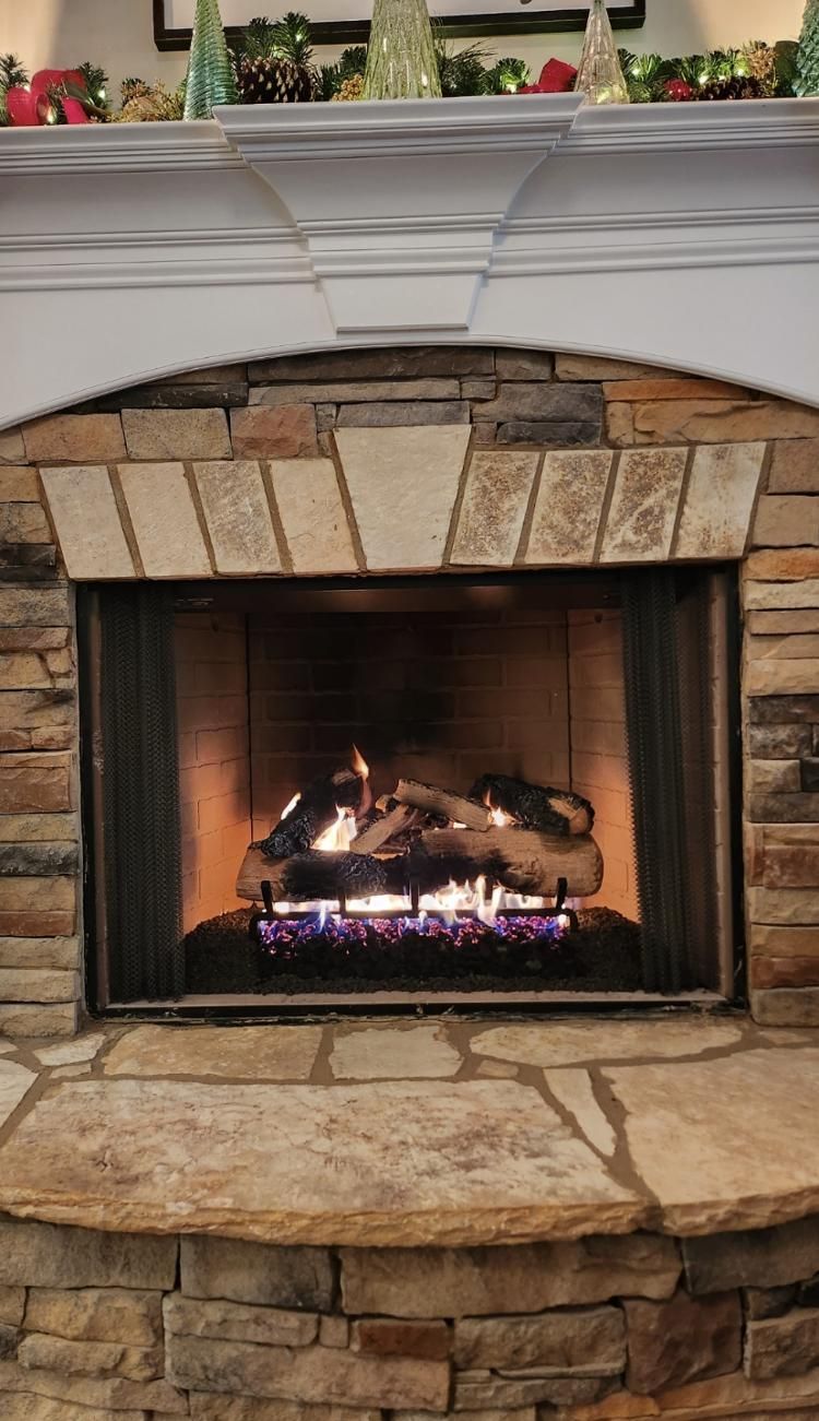 A fireplace with a mantle and christmas decorations on it