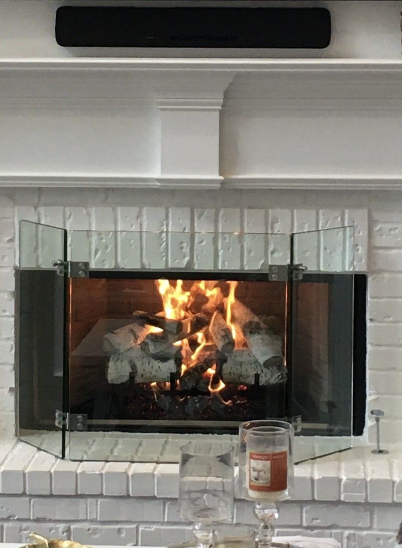 A fireplace with a glass screen and a candle in front of it.