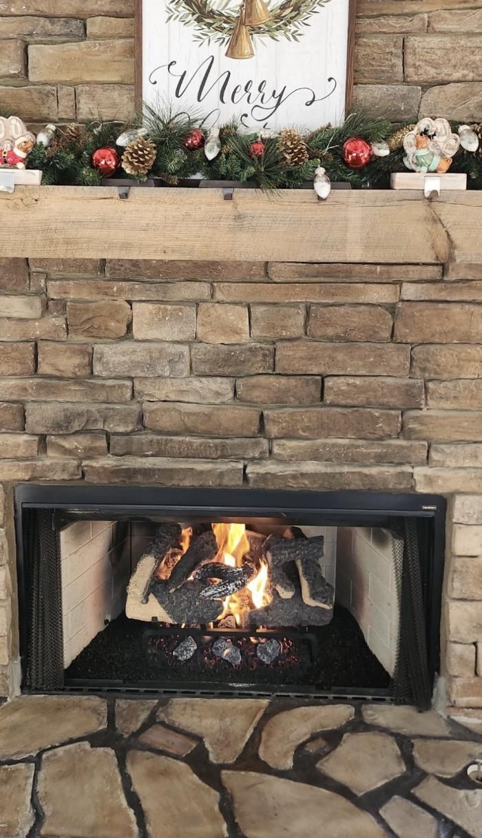 A fireplace with a sign on the mantle that says merry christmas.