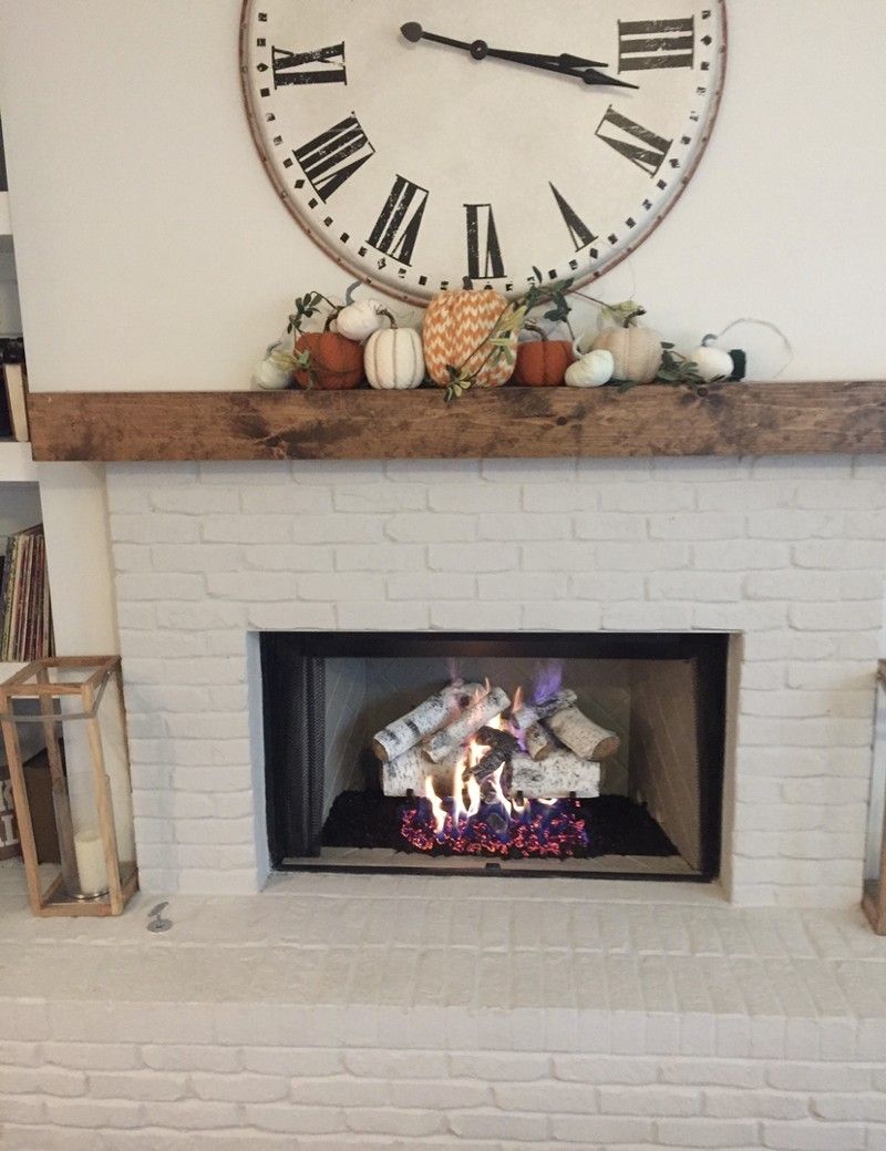 A fireplace with a clock on the wall above it