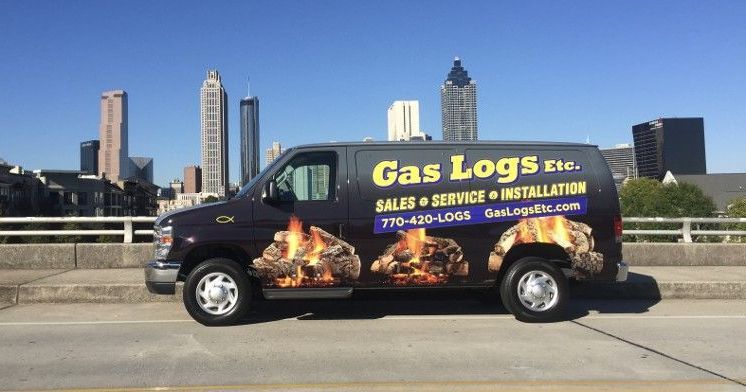 A gas logs van is parked on the side of the road.