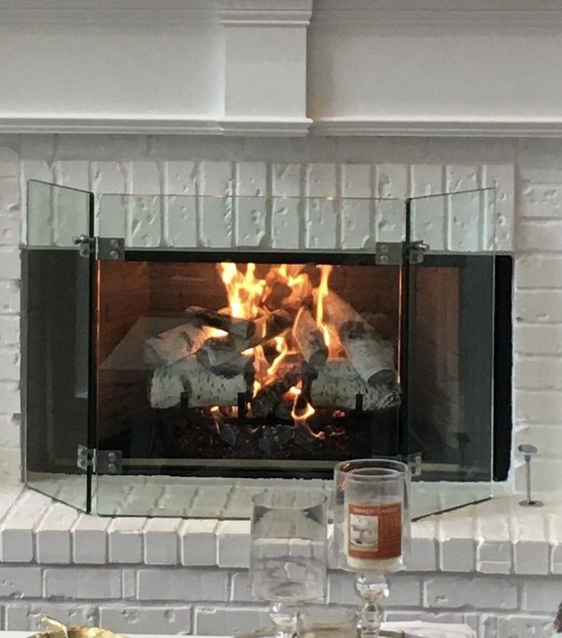 A fireplace with a glass screen and a candle in front of it