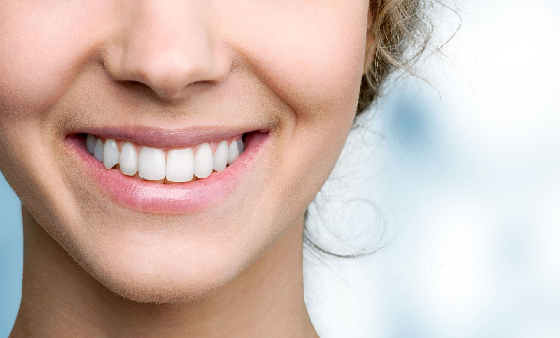 A close up of a woman 's smile with white teeth.