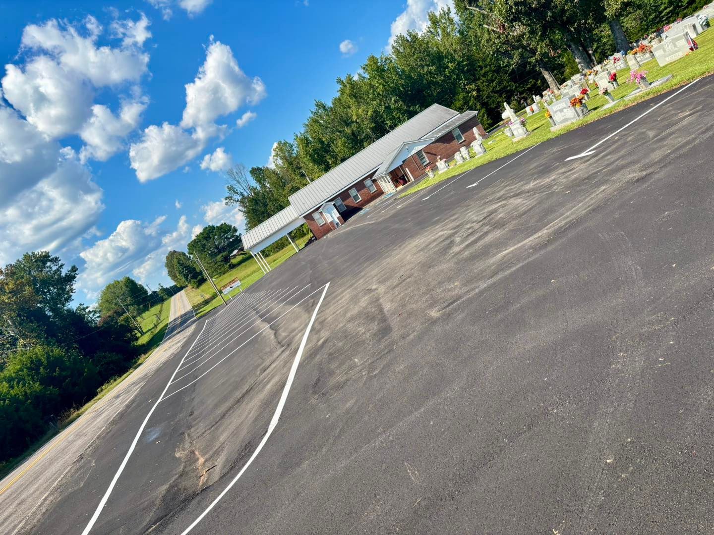Tilted view of an empty paved lot beside a small pavilion under a bright blue sky