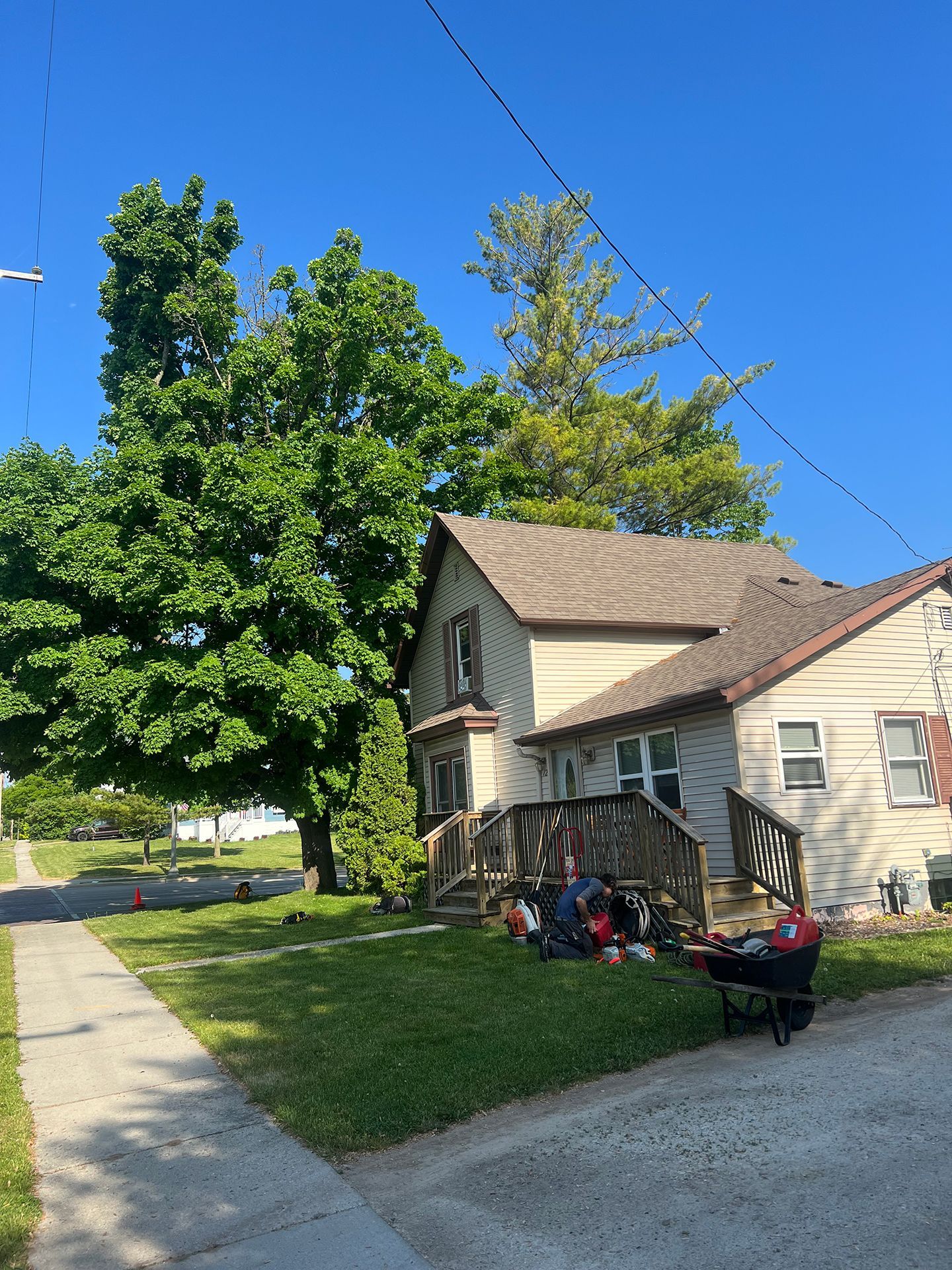 A group of people are sitting in front of a house on a sunny day.