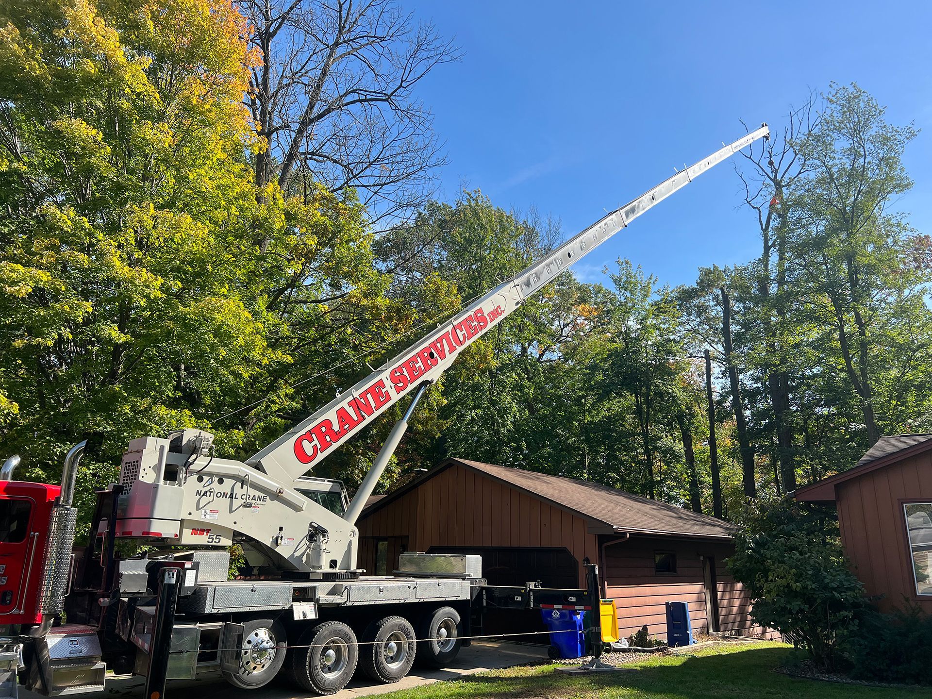 A large crane is parked in front of a house.