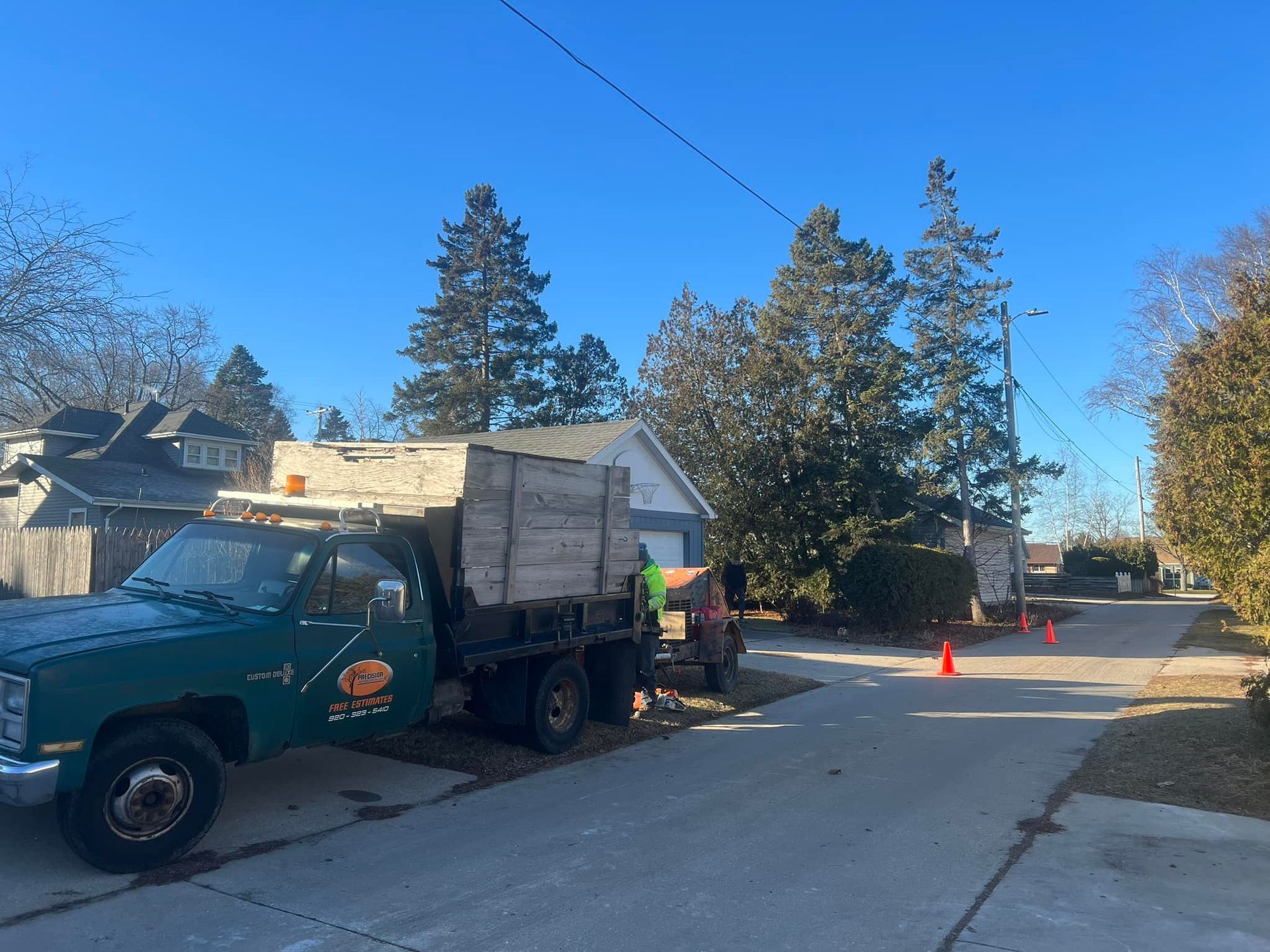 A green truck is parked in the driveway of a house.