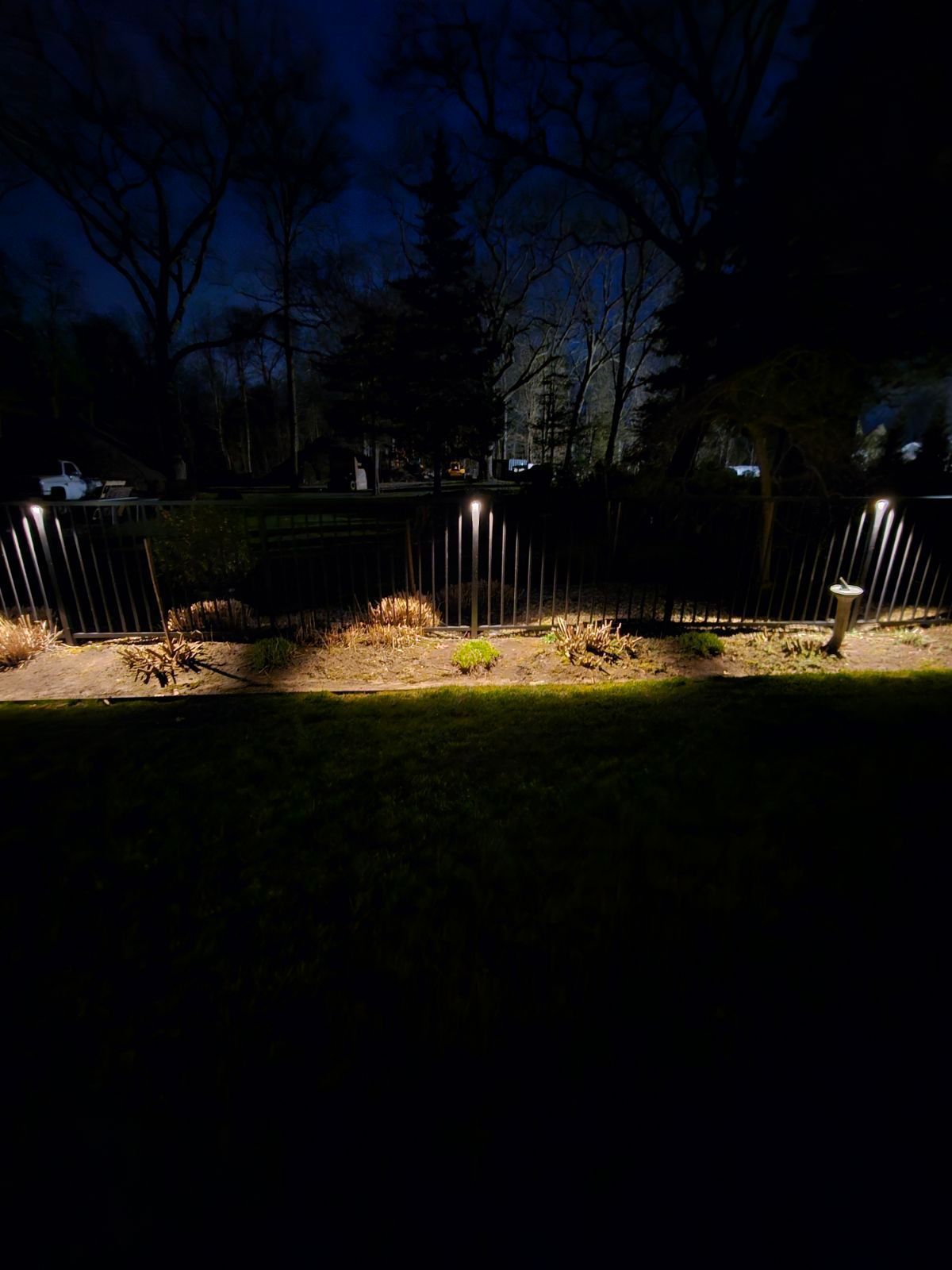 A fence with lights on it is lit up at night