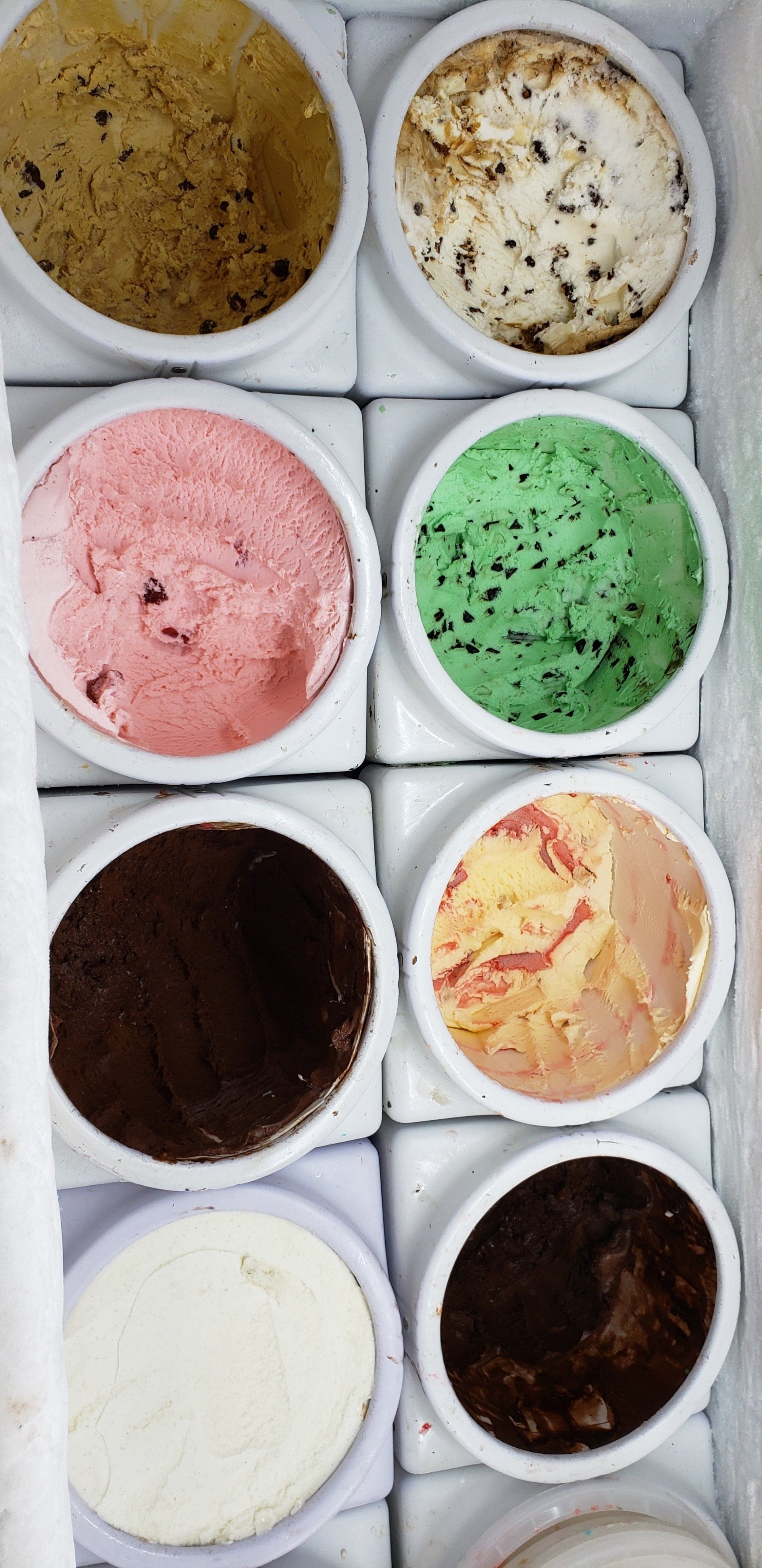 There are many different flavors of ice cream in the bowls.