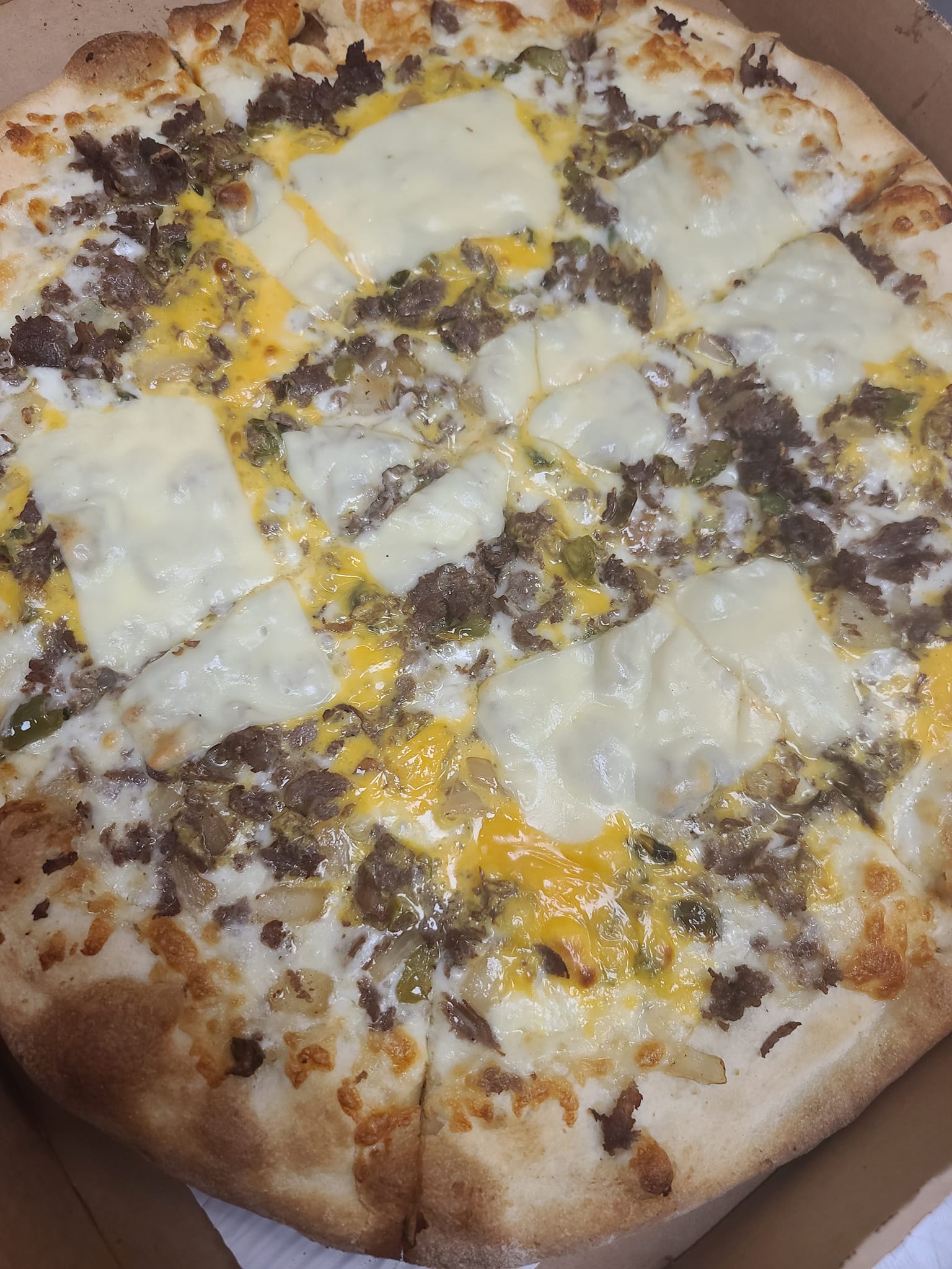 A pizza with a lot of cheese and meat is in a box.