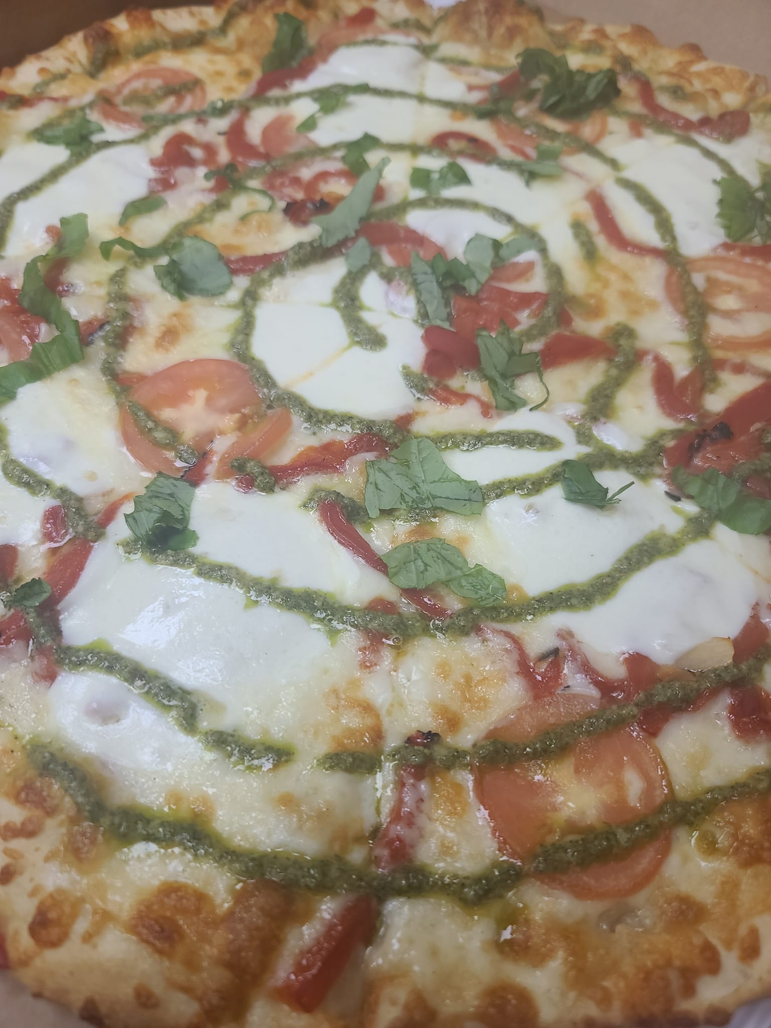 A pizza with a lot of toppings on it is in a box.