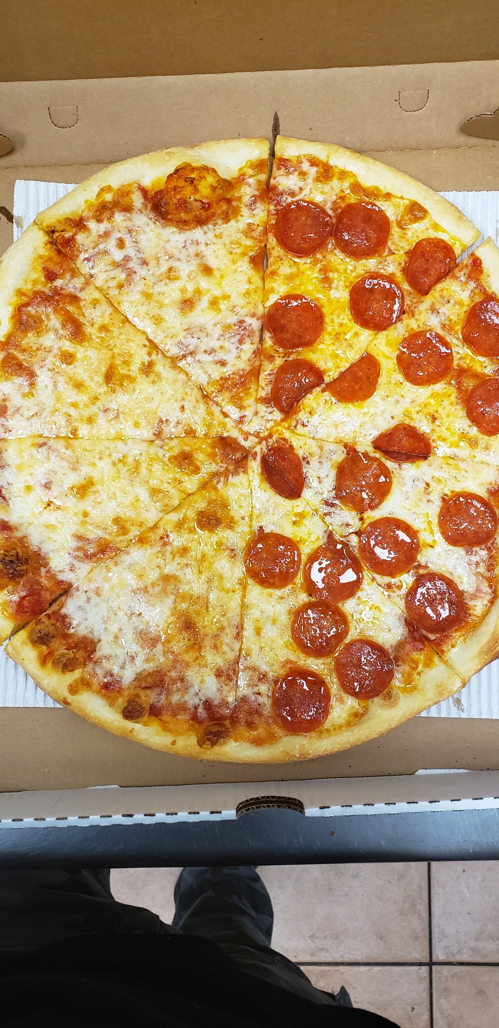 A pizza with pepperoni and cheese is in a box.