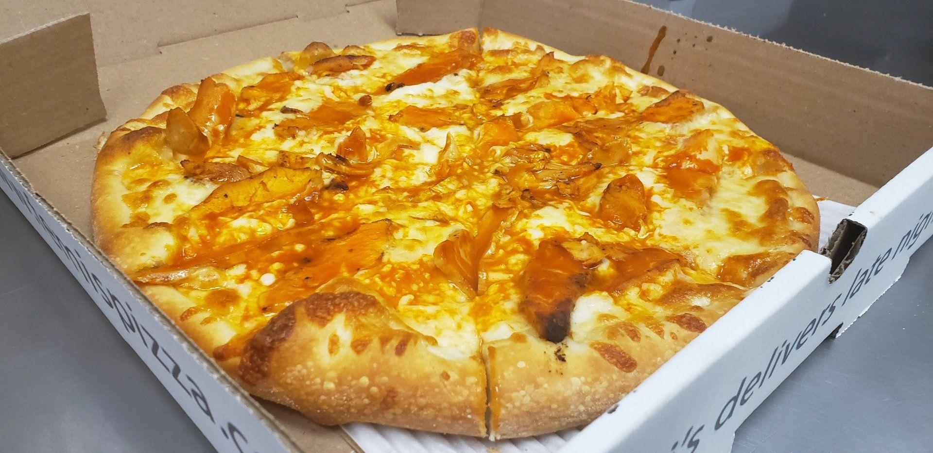 A pizza is sitting in a cardboard box on a table.