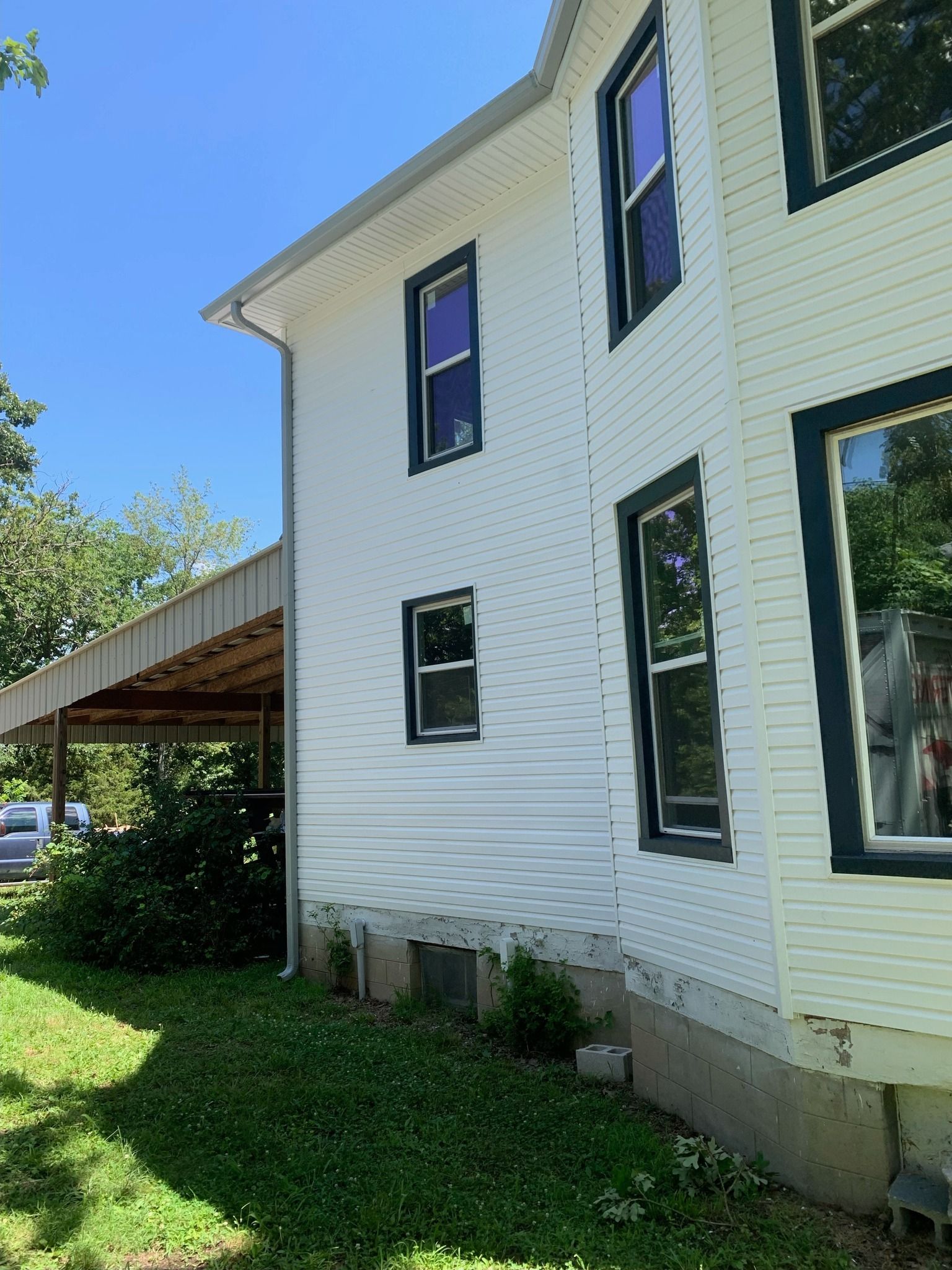 White house exterior with dark window trim and a covered walkway.