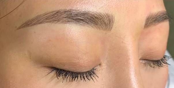 a close-up of a woman 's eyebrows after microblading