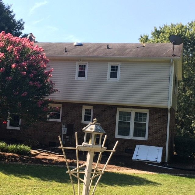A house with a bird feeder in front of it