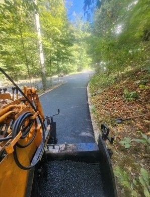 Asphalt paving a winding road through a wooded area