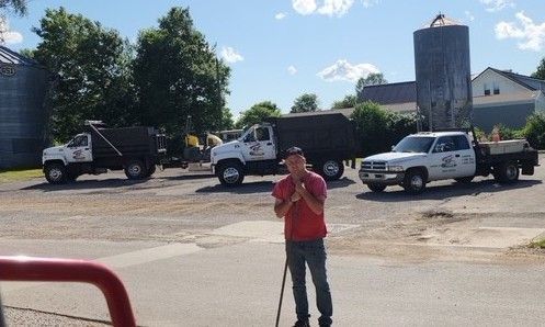 Man stands in front of three work trucks