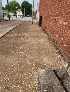 Construction zone: gravel sidewalk next to a brick wall
