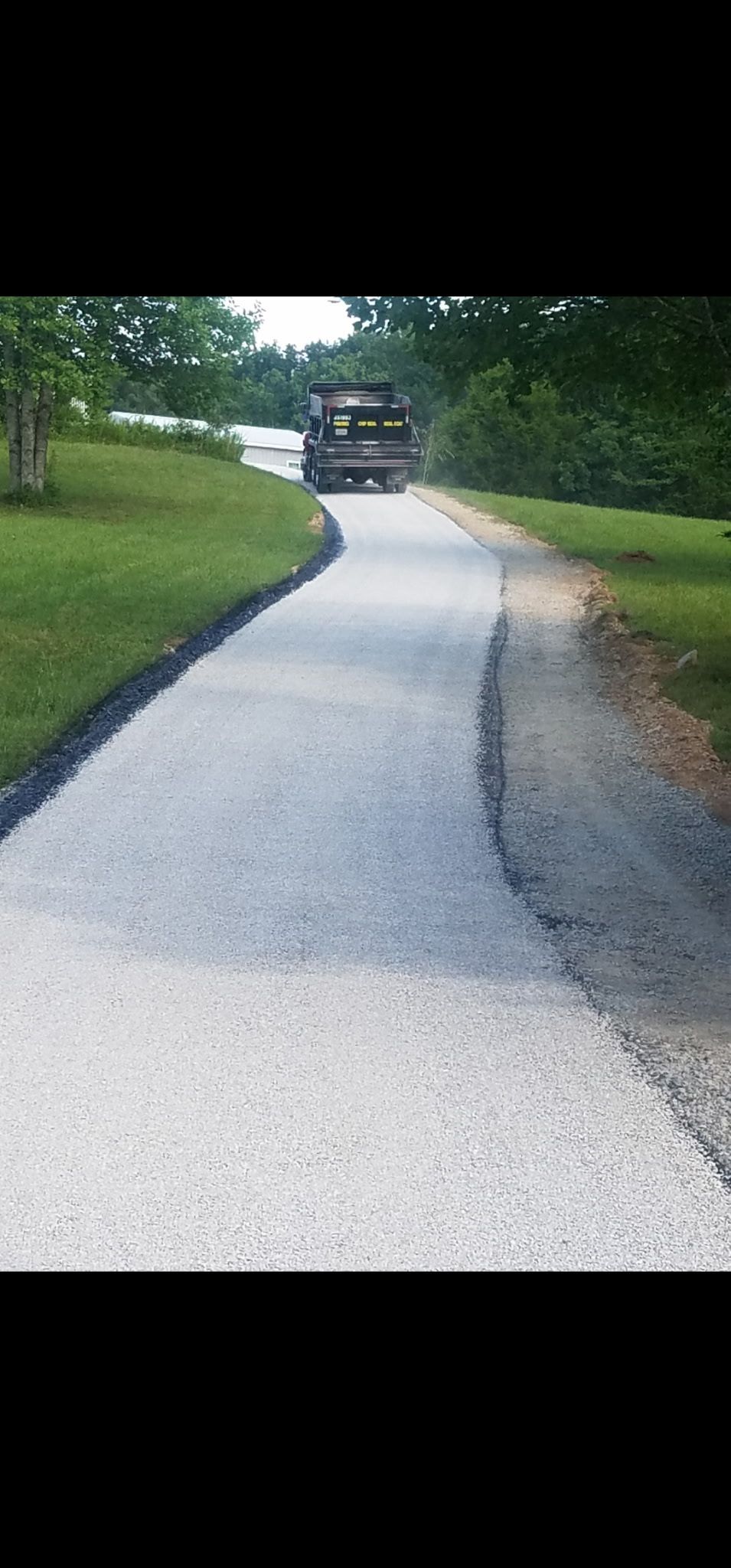 A gravel driveway curves uphill