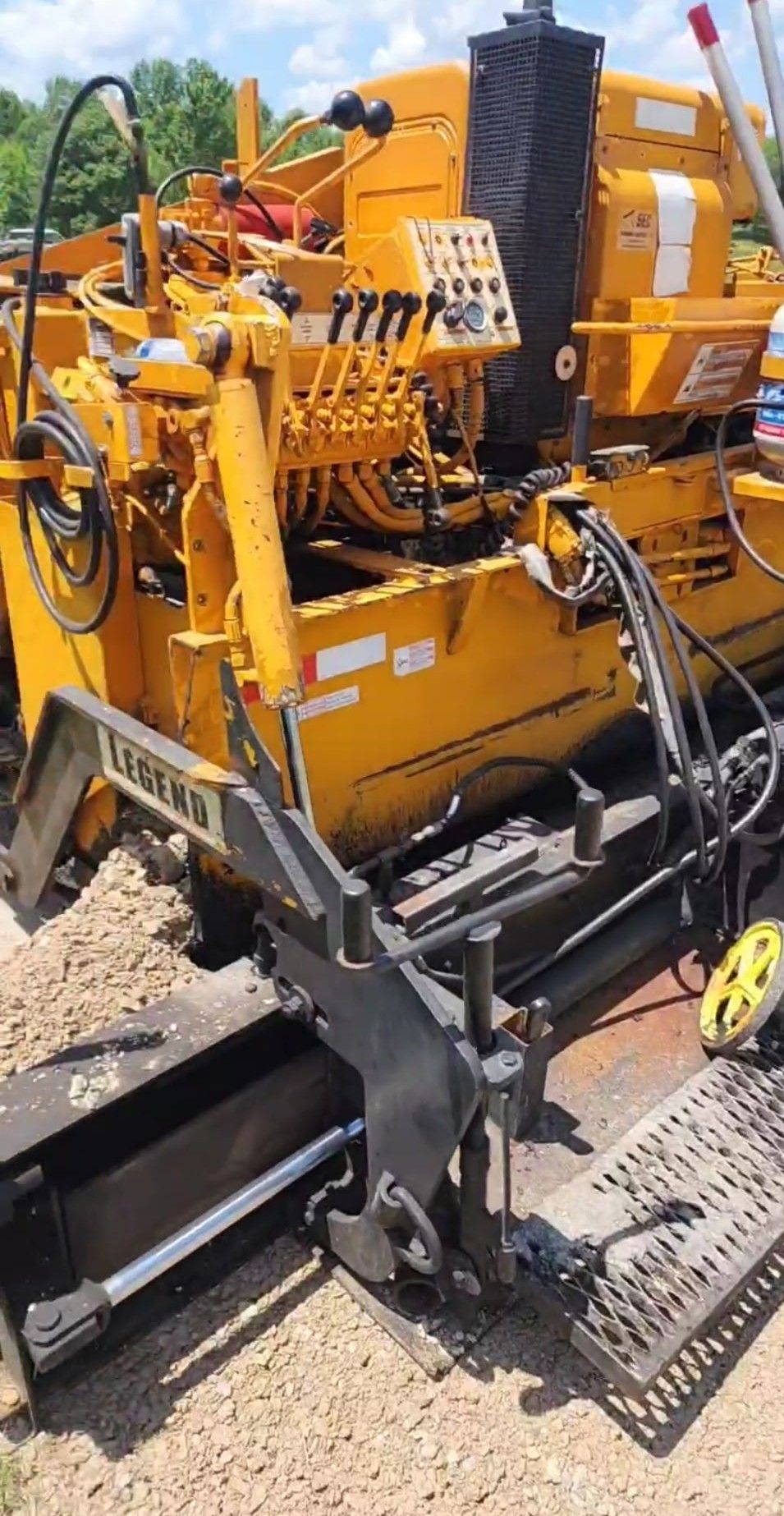 Yellow asphalt paving machine on gravel