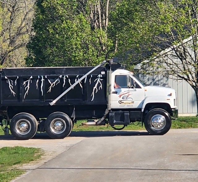 White dump truck with a black bed and decorative lightning bolts