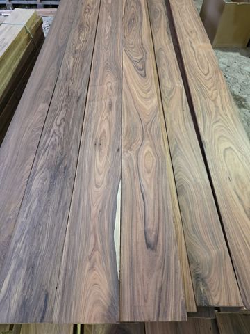 Dark wood planks stacked, showing varying grain patterns and hues of brown.
