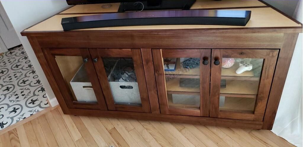 A wooden entertainment center with a television on top of it.