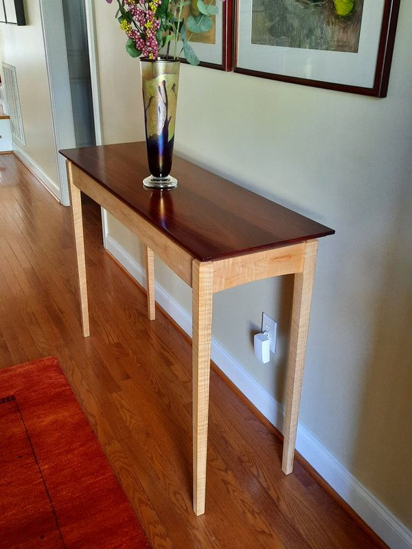 A wooden table with a vase of flowers on it
