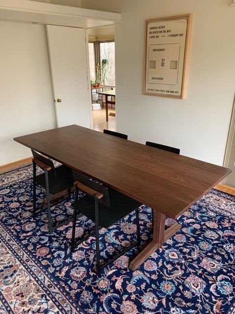 A wooden table and chairs in a room with a rug