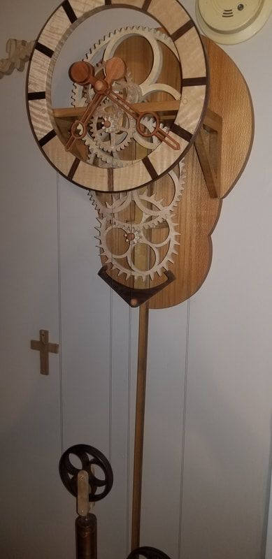 A wooden clock with gears on it is hanging on a wall.