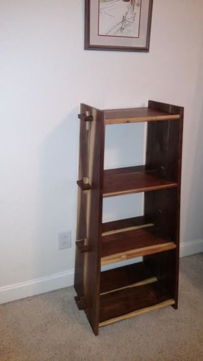 A wooden bookshelf is sitting in a room next to a wall.