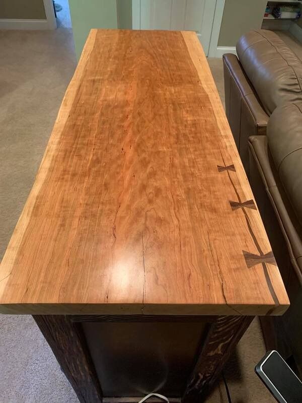 A wooden table is sitting in a living room next to a couch.