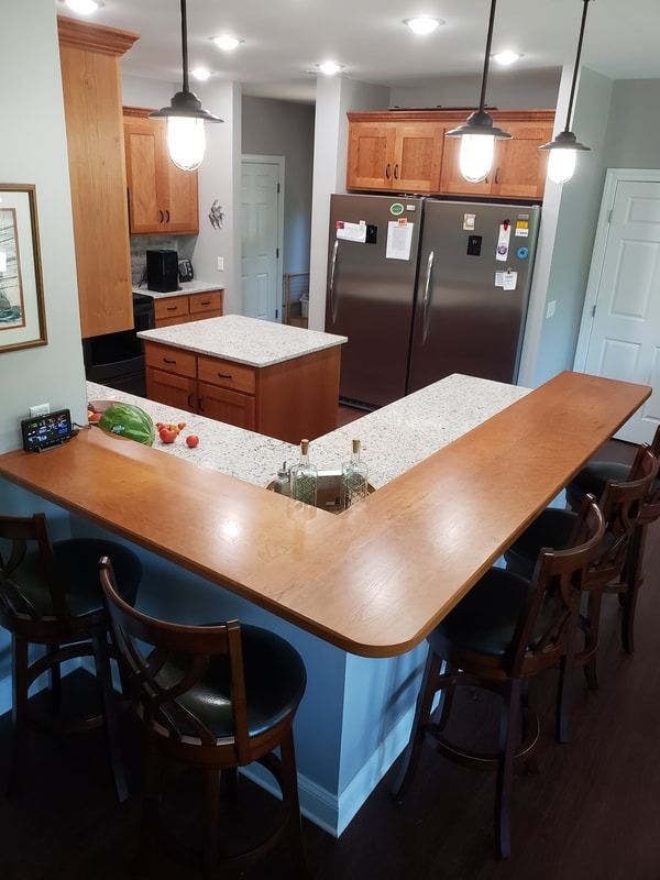 A kitchen with a large wooden counter and stools