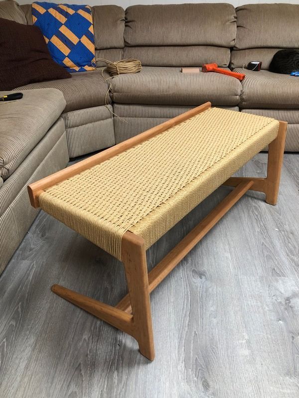 A wooden bench is sitting in front of a couch in a living room