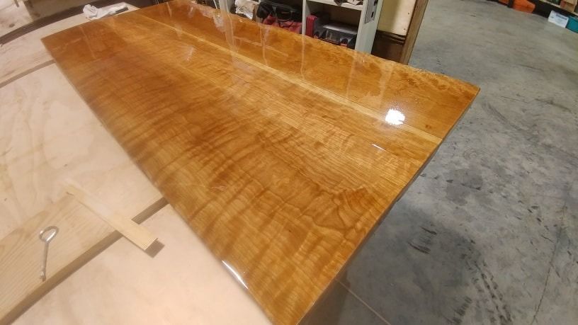 A large wooden table is sitting on top of a concrete floor.