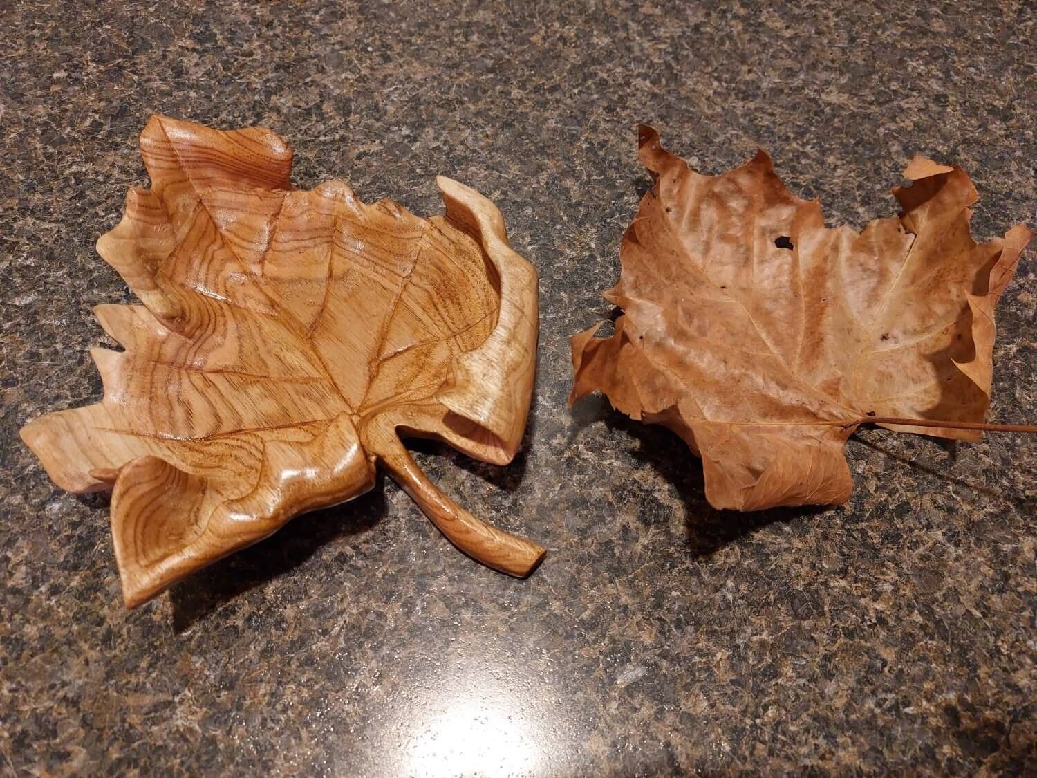 Two wooden leaves are sitting on a counter.
