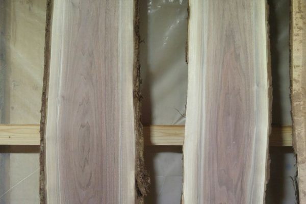 Two pieces of wood are sitting on top of each other on a wooden shelf.