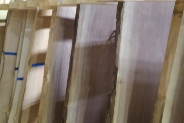 A row of wooden boards stacked on top of each other in a warehouse.