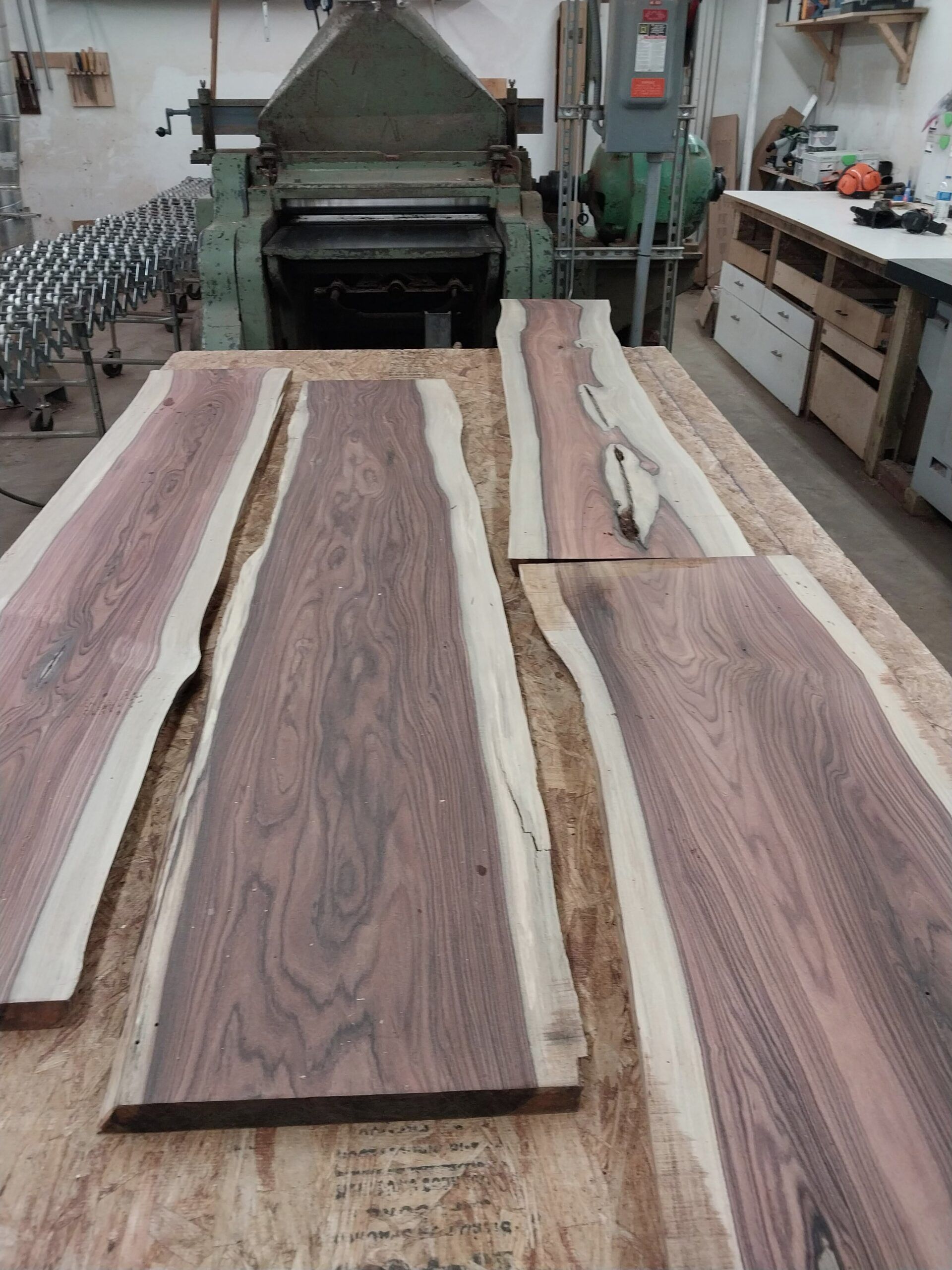 Three pieces of wood are sitting on a table in a workshop.
