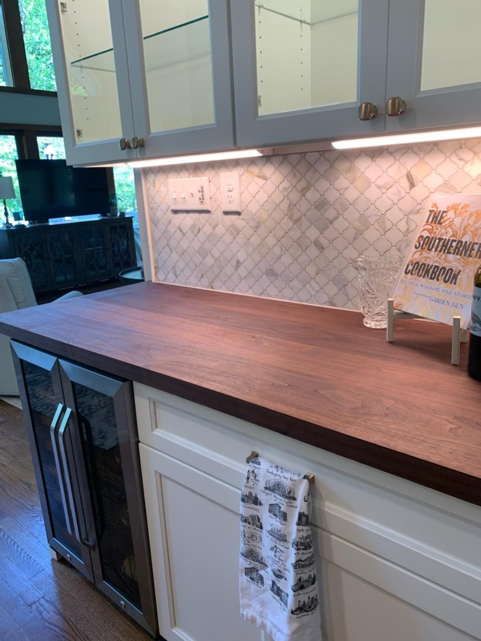 A kitchen with a wooden counter top and white cabinets.
