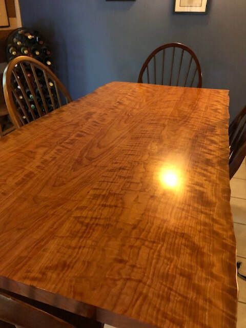 A wooden table with chairs in a dining room.