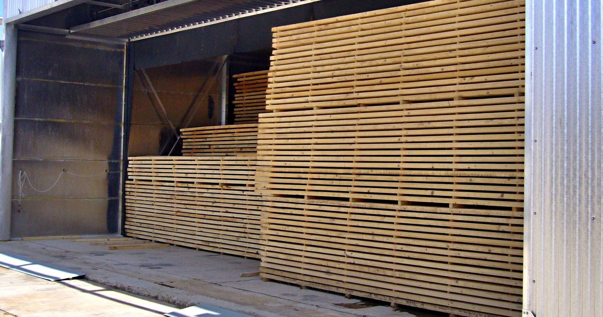 A warehouse filled with lots of wooden boards stacked on top of each other.