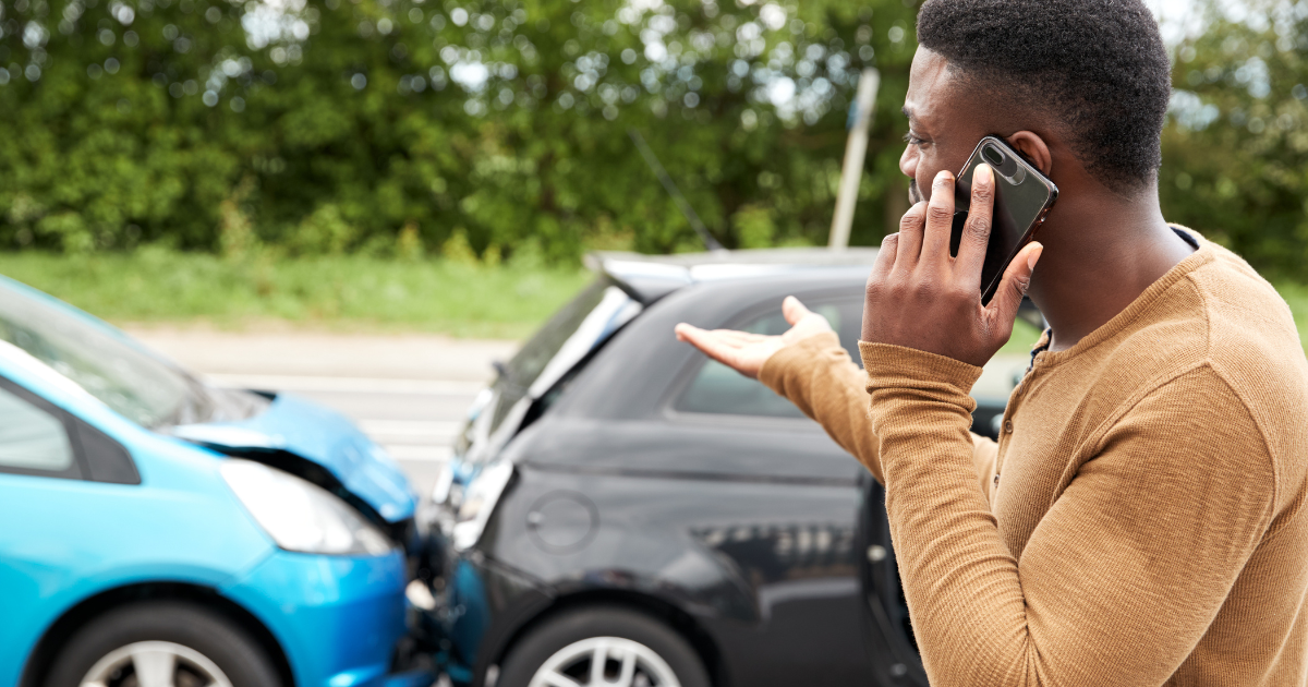 man on cell phone near a car accident