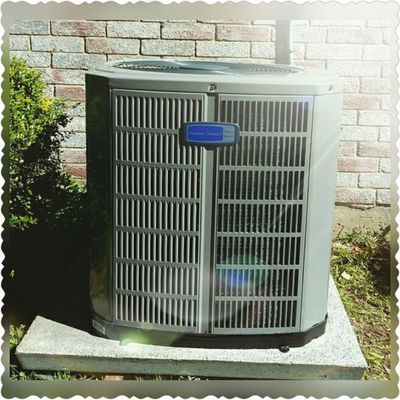 Air conditioning unit outside a brick building.