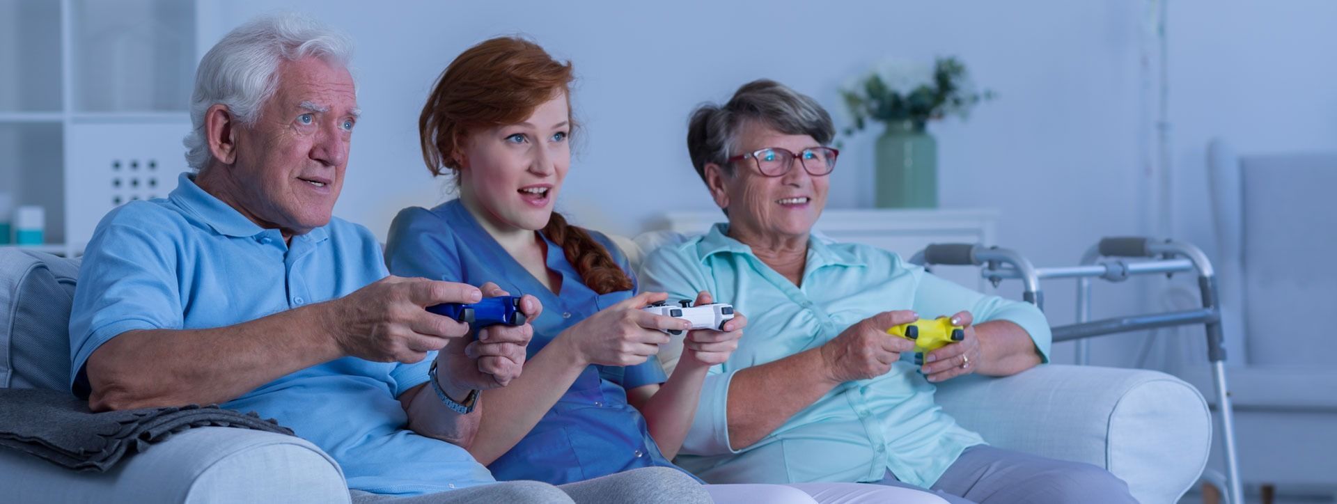 Three people sitting on a couch, smiling and playing video games together.