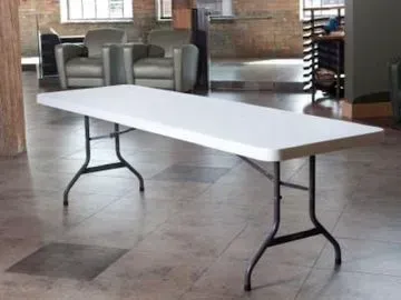 White rectangular folding table with black metal legs in a room.