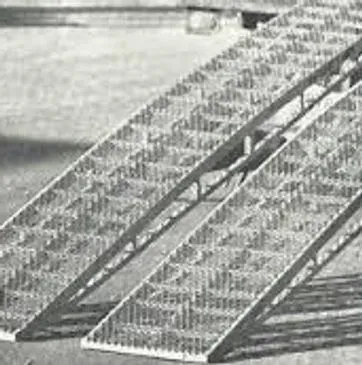 Metal ramps with diamond pattern for loading, likely outdoors on concrete.
