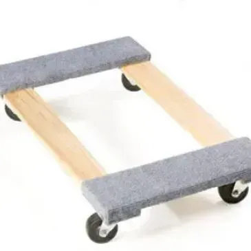 A wooden furniture dolly with four black wheels and carpeted ends, on a white surface.