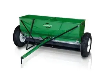 Green Gandy broadcast spreader on wheels, used for dispensing fertilizer or seed.